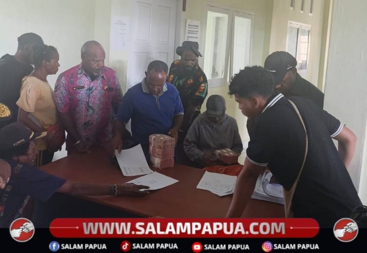 Kadis Sosial dan Tenaga Kerja Nduga, Jorim Murib (pakai batik) menyaksikan proses penyerahan dana PKH II dari Pemkab Nduga, Kamis (11/6/2026)(Salampapua.com/Elea Worom)