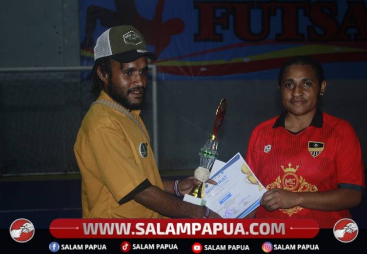 Ketua Panitia Seminar, Natal, dan Tahun Baru Ikatan Pelajar Mahasiswa Mimika (IPMAMI) Se-Jawa Bali 2026–2027, Melian Magal (kiri), menyerahkan trofi dan sertifikat kepada perwakilan tim MANJA Putri sebagai Juara I kategori putri pada Turnamen Futsal IPMAMI Se-Jawa Bali 2026 di Dewa Futsal Bandung, Sabtu (11/7/2026)(Salampapua.com/Dokumen IPMAMI)
