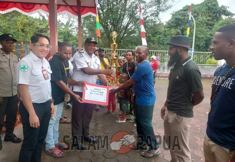 Kepala Distrik Kwamki Narama didampingi Kepala Puskesmas Kwamki, perwakilan Polsek Kwamki dan panitia menyerahkan hadiah uang pembinaan dan piala kepada Juara 1 voli putra (Foto:salampapua.com/Acik)