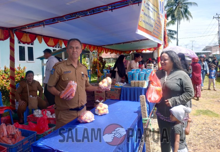Kepala Disperindag Mimika saat melayani seorang ibu rumah tangga di Jalan Baru yang berbelanja di pasar murah (salampapua.com/Acik)