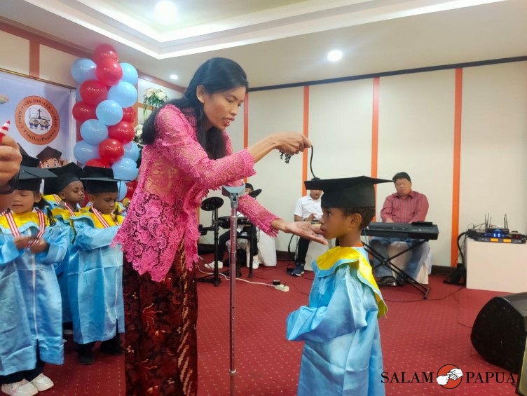 Pemindahan toga oleh Kepala TK Miracle School Irama Sembiring (Foto:salampapua.com/Acik)