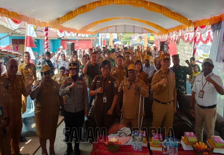 Foto bersama dengan latar masyarakat Kelurahan Koperapoka (Foto:salampapua com/Acik)