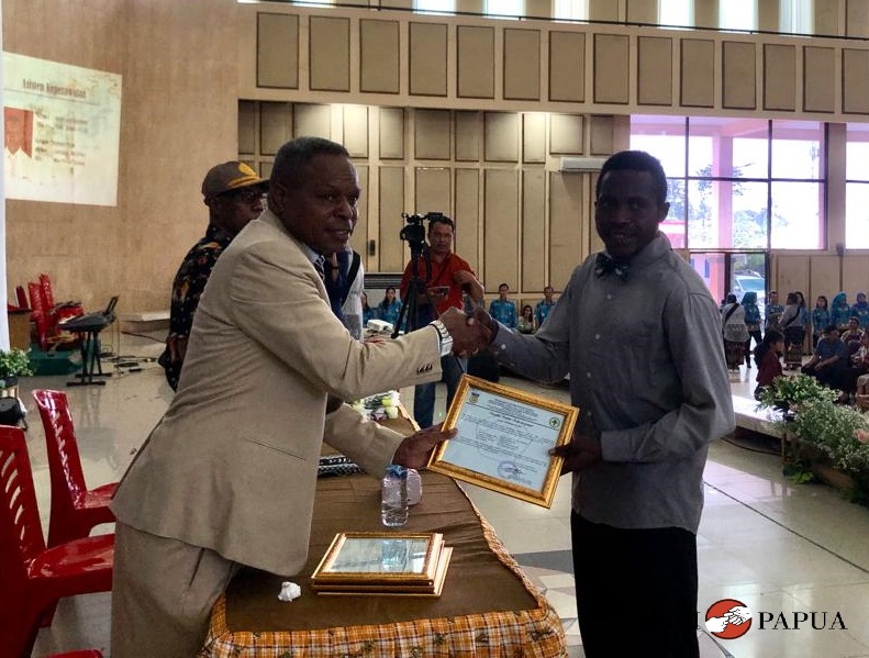 Salah satu siswa SMKN 3 Mimika saat menerima piagam penamatan dari Kepala Sekolah Jhon Lemauk (Foto:Salampapua.com/Evita)